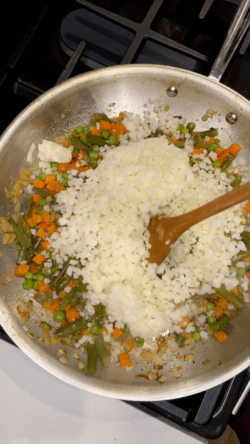 Add cauliflower rice and veggies and stir.
