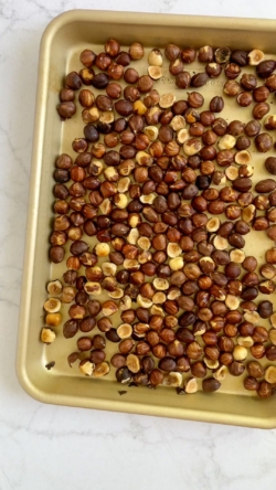 Add hazelnuts to a baking sheet and bake for 8 minutes or just until they begin to brown.