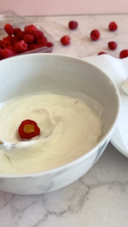 Dip each raspberry in a bowl of yogurt until each one is fully covered.