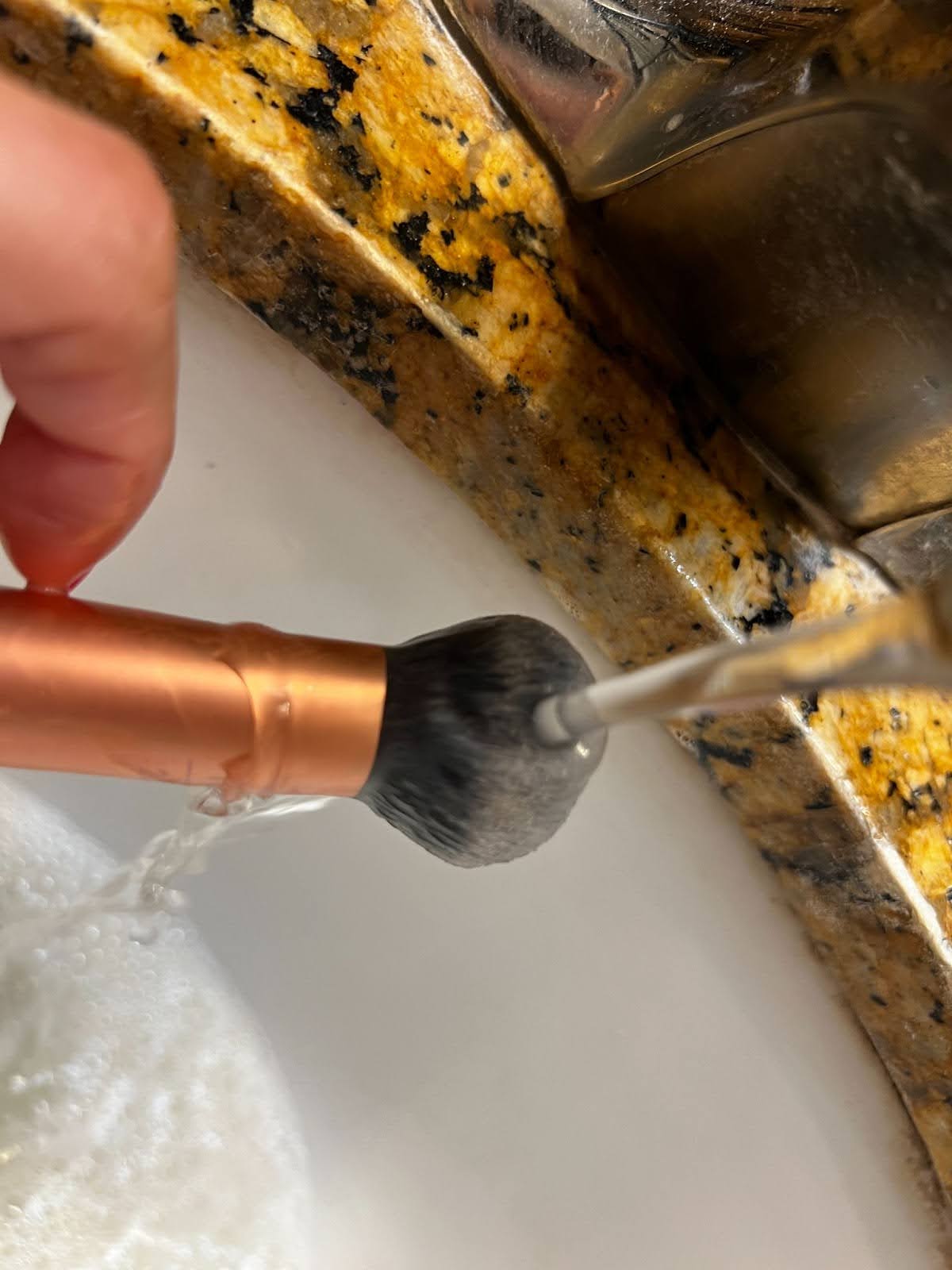 Rinse the makeup brush under running water to clean away soap and makeup, and repeat step 2 until the water runs clear.